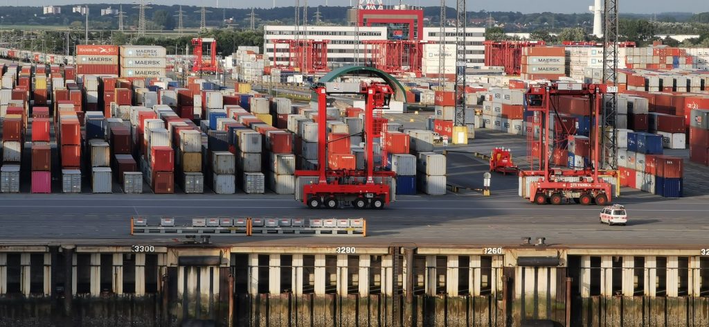 Cargo containers and cranes at a European seaport, representing freight network membership for EU and UK forwarders