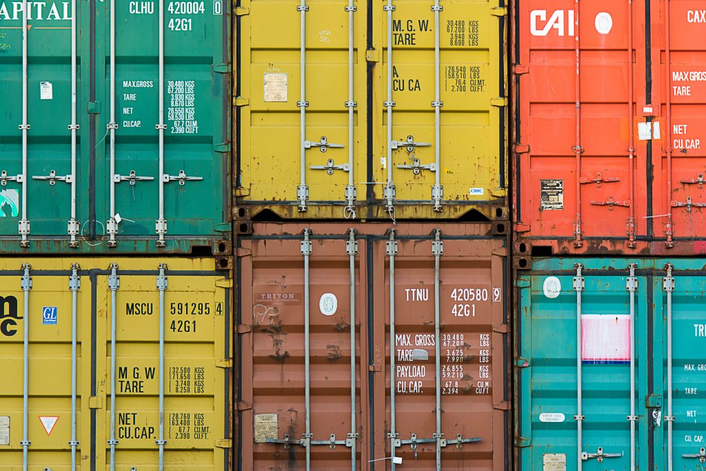 Stacked shipping containers representing global freight partner access and trade lane coverage