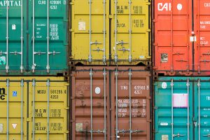 Stacked shipping containers representing global freight partner access and trade lane coverage