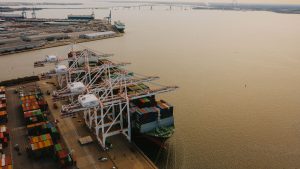 Container vessel loading at a North American port, representing cross-border freight network coverage across the U.S., Canada, and Mexico
